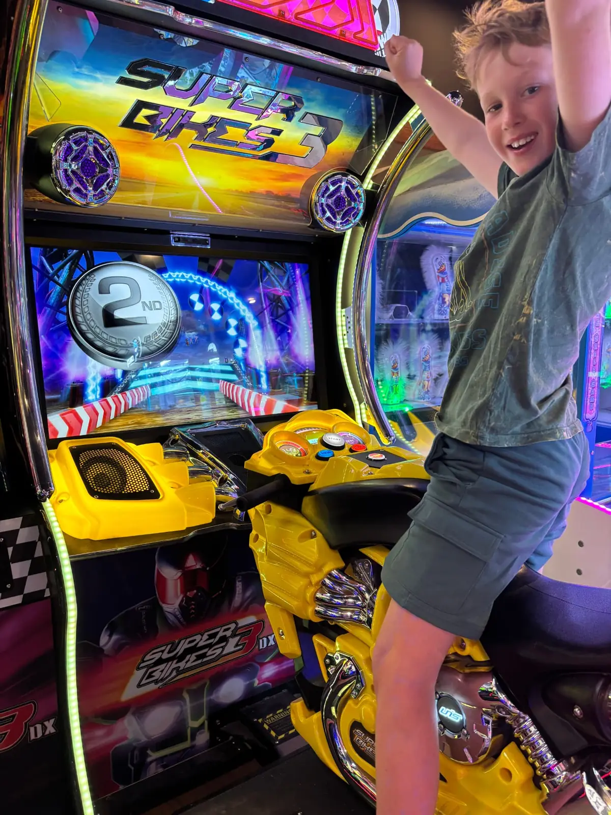 Child celebrating on the Super Bikes arcade game at Bendigo Bowl